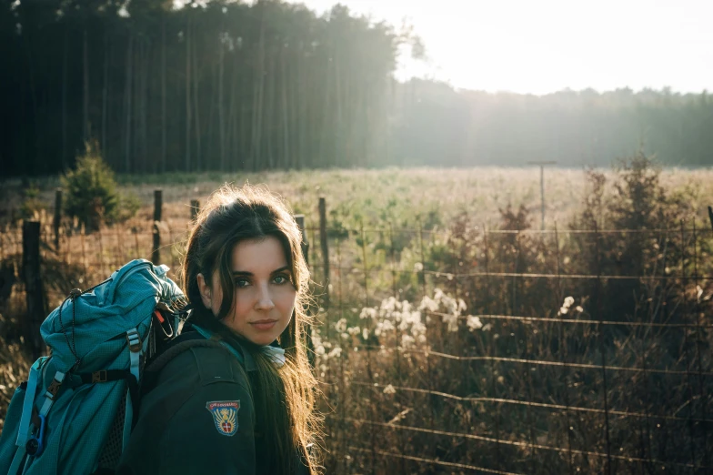 a woman carrying a backpack and looking down at soing