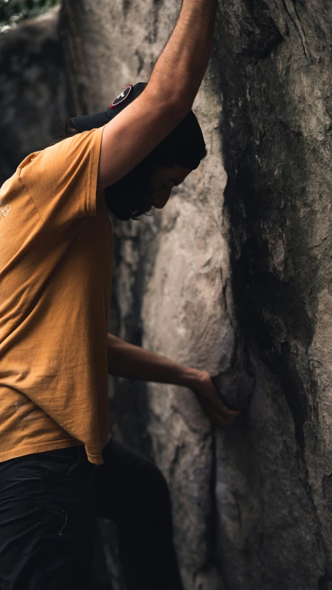 a man on a rock climbing up a mountain side