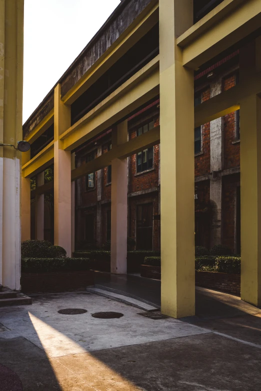 an empty parking lot with columns and windows in a building