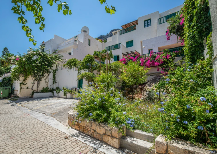 the side of a building is surrounded by flowers and greenery