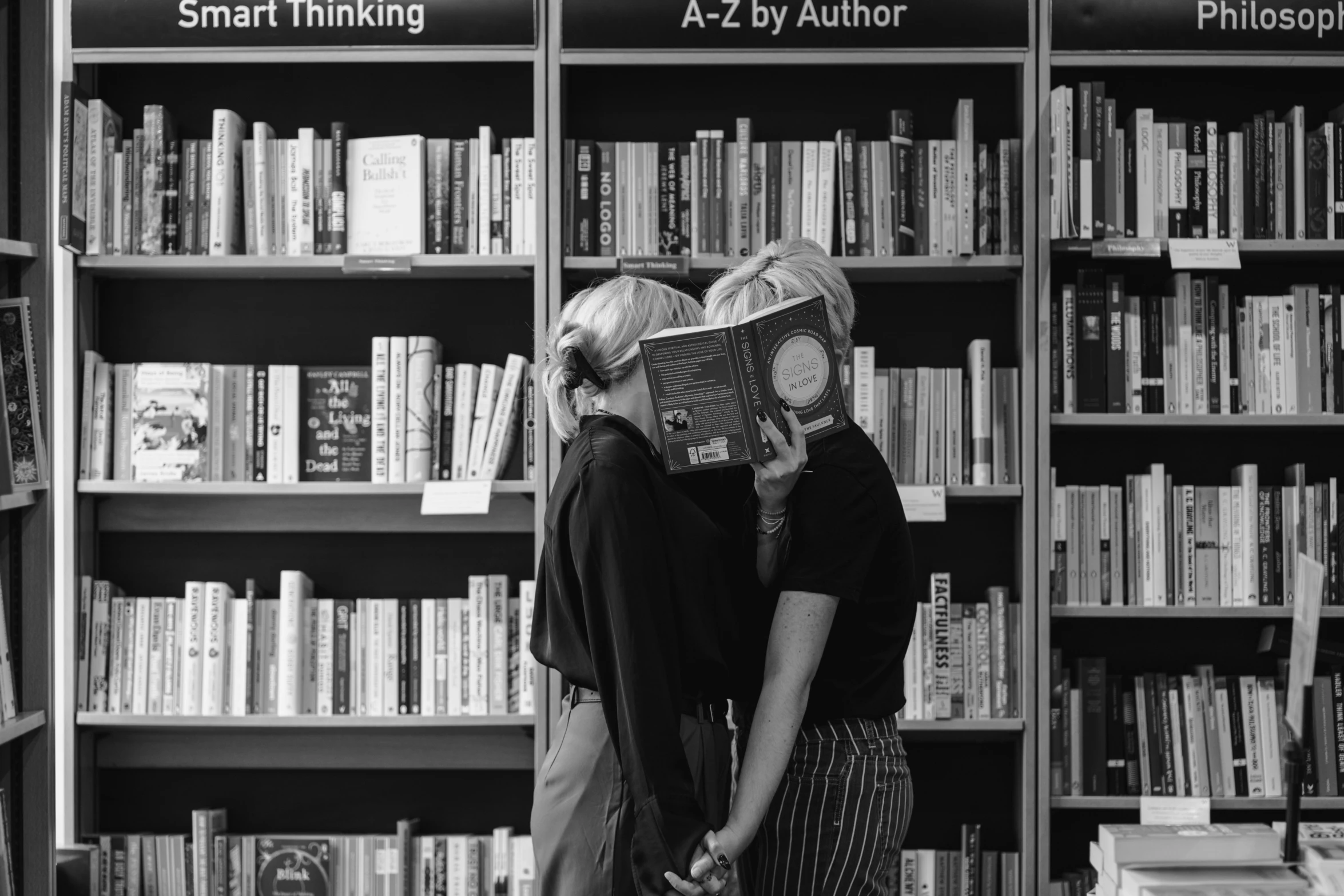 two young women are sharing a book together in a liry