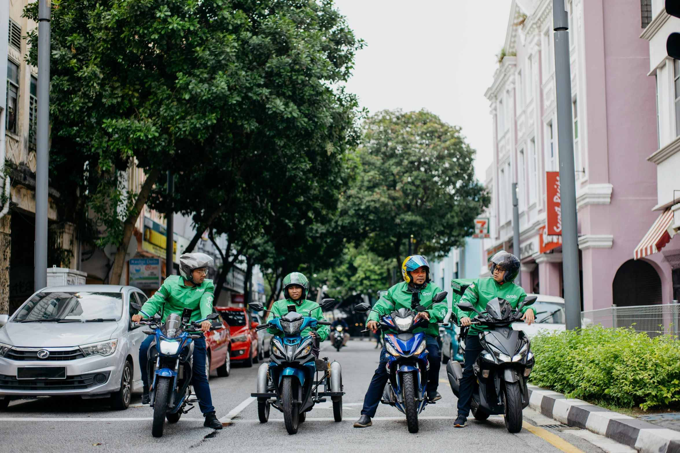 three men are riding on the same motorcycle in a city