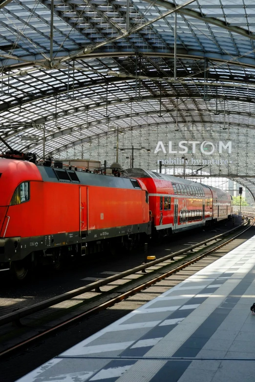 a red train that is pulling into a train station