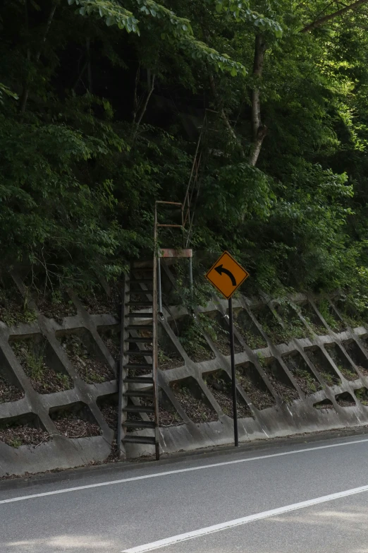 a yellow sign that is near a road