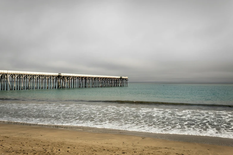 the pier stretches over the ocean as it is dark