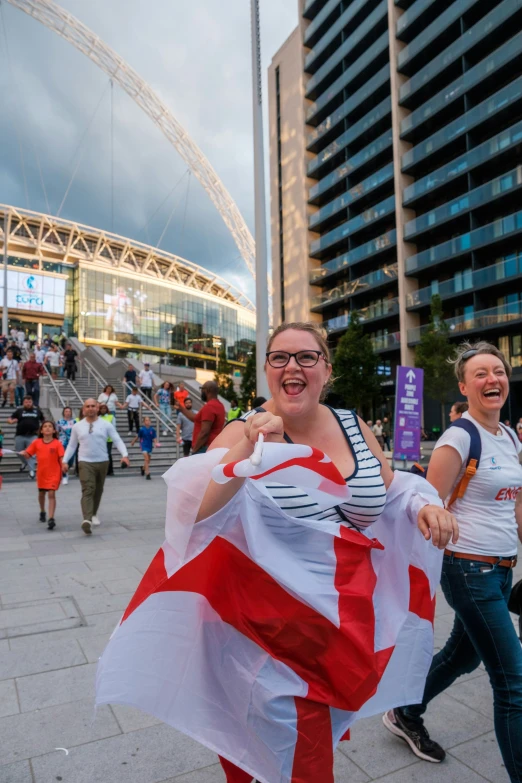 a woman smiles as she holds a red white and blue flag