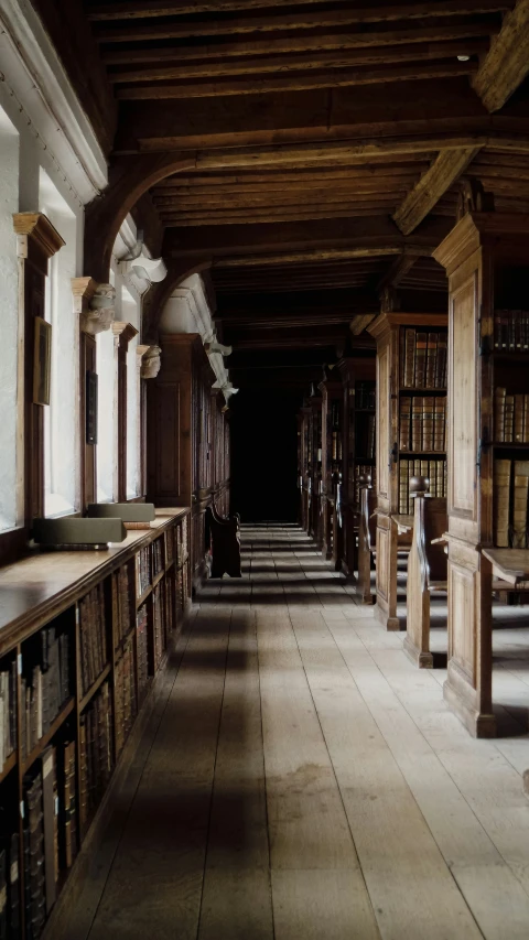 a long empty liry with benches lined up against the book shelves