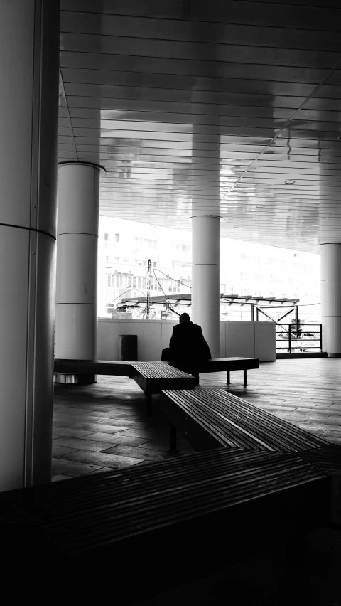 a person sitting on a bench looking at his phone