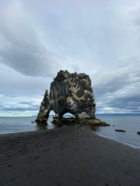 an overcast sky shows the rocks on the shore