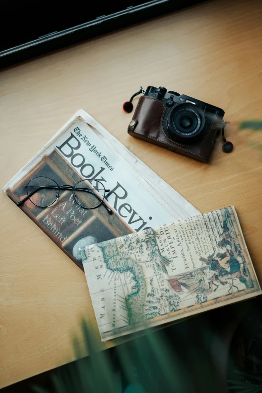 a camera and passport sitting on top of a wooden table