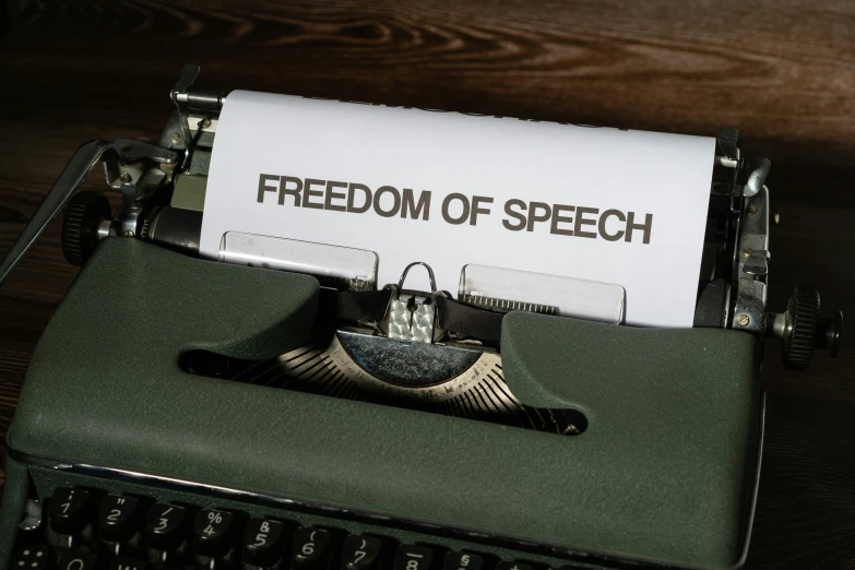 a typewriter with paper that reads freedom of speech