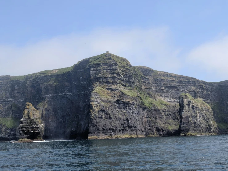 a large boat sailing past a very large mountain