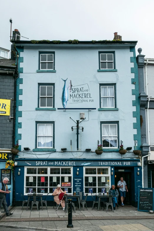 a blue building that has people in front of it