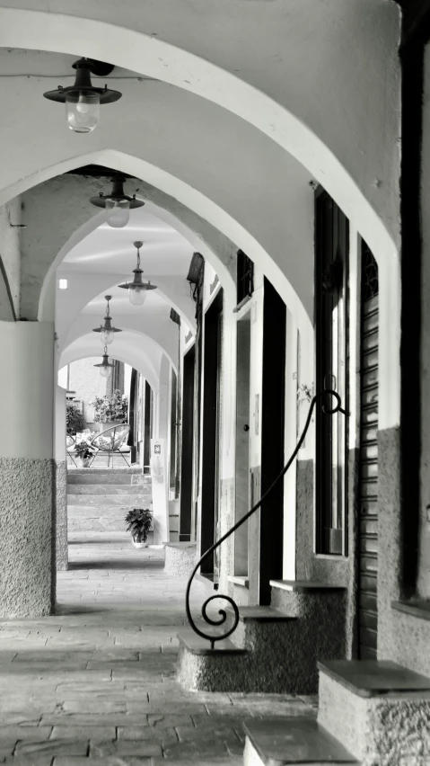 a walkway with benches and lanterns on it