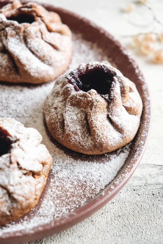 powdered sugar cookies with a chocolate filling and sprinkles