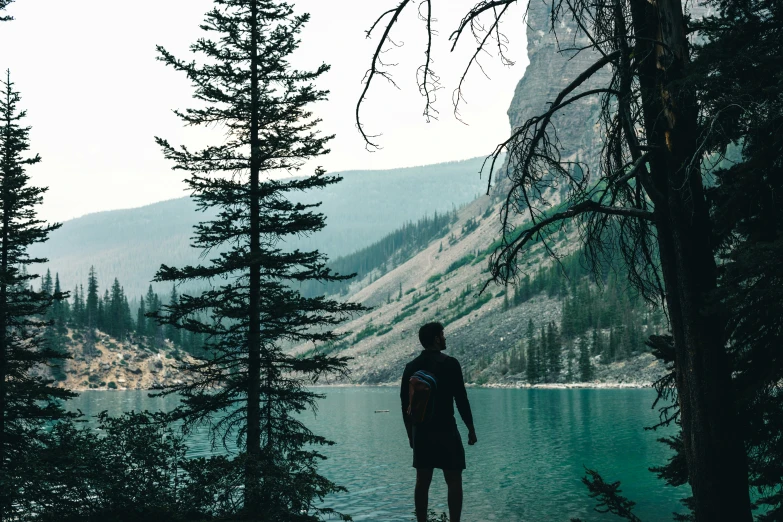 person standing on shore looking out over a lake