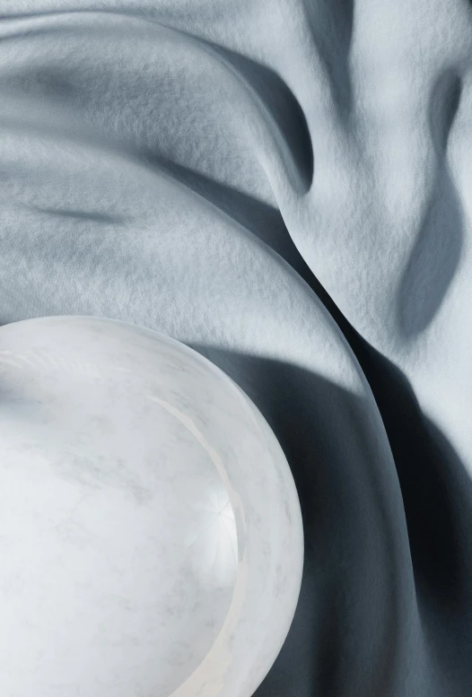 a white vase on a black cloth next to a silver plate