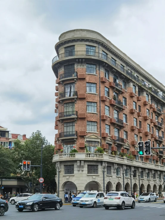 cars sit on the street next to a tall building