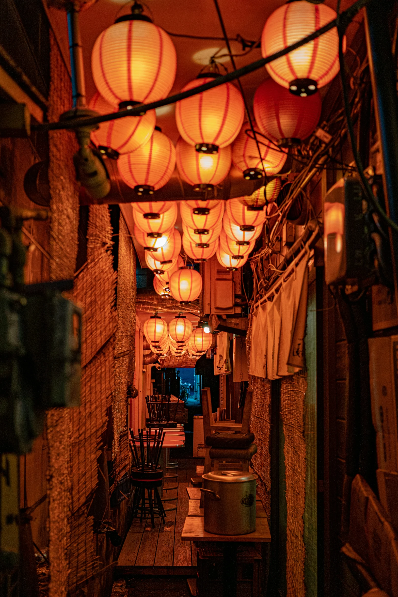 lanterns hanging from the ceiling and lamps on the side of a building