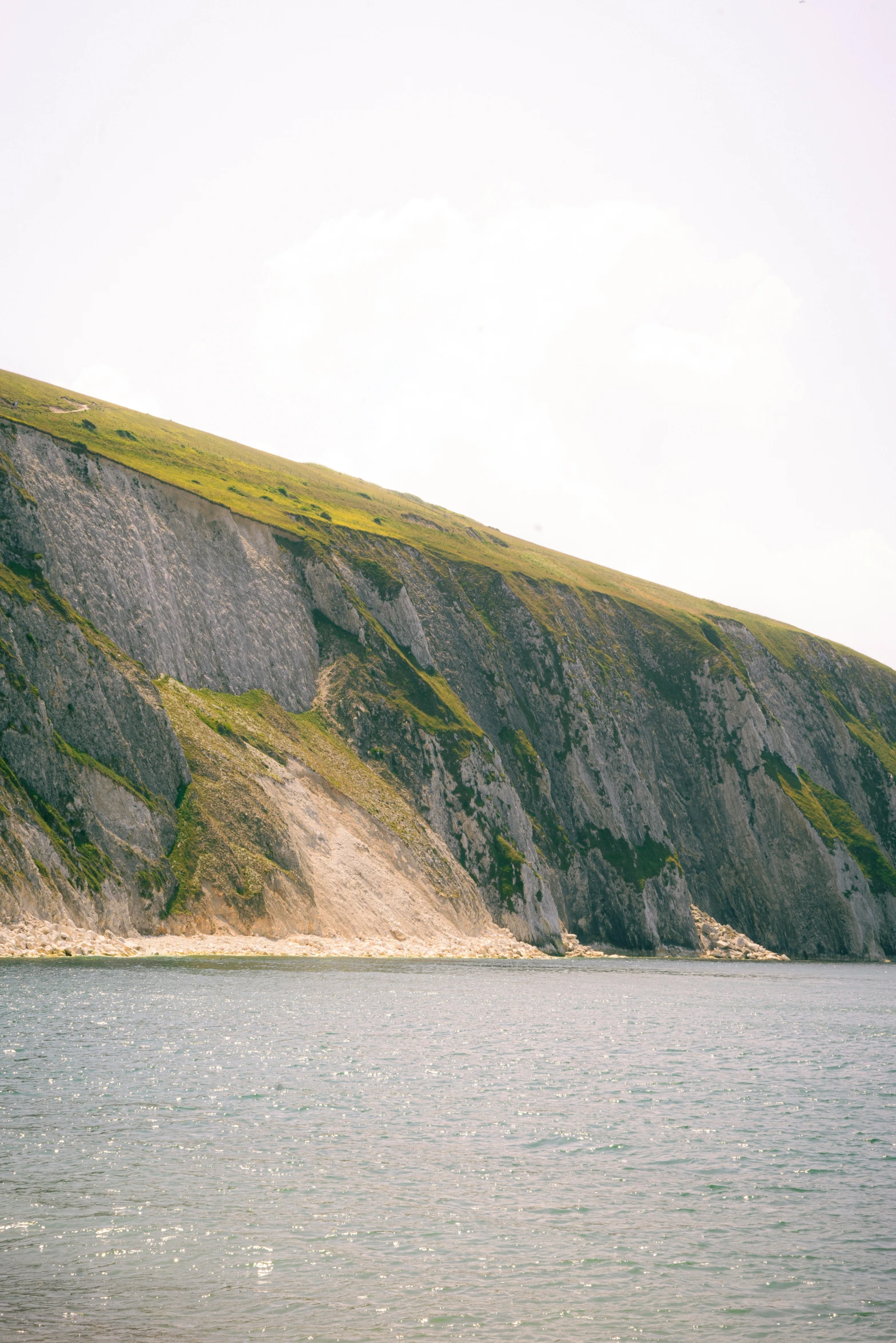 a rocky hillside overlooks the lake, making it appear to be far off in the distance