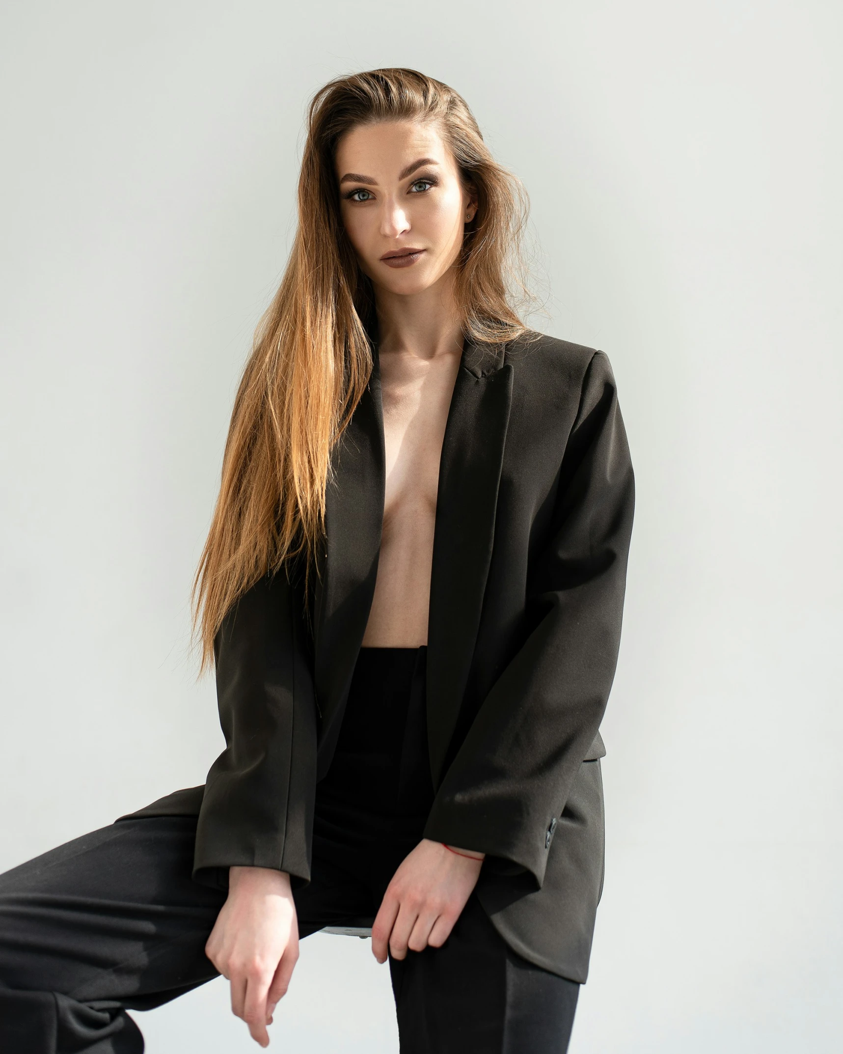 a girl with long red hair posing in a black suit