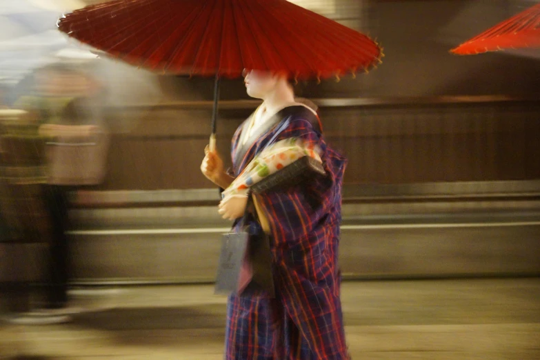 an asian woman wearing a kimono holding a umbrella