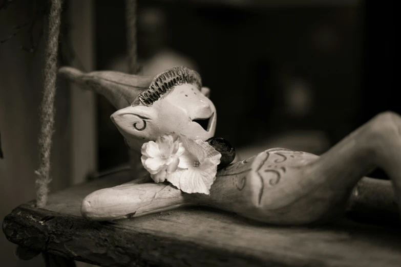 a very small creepy doll sitting on a shelf