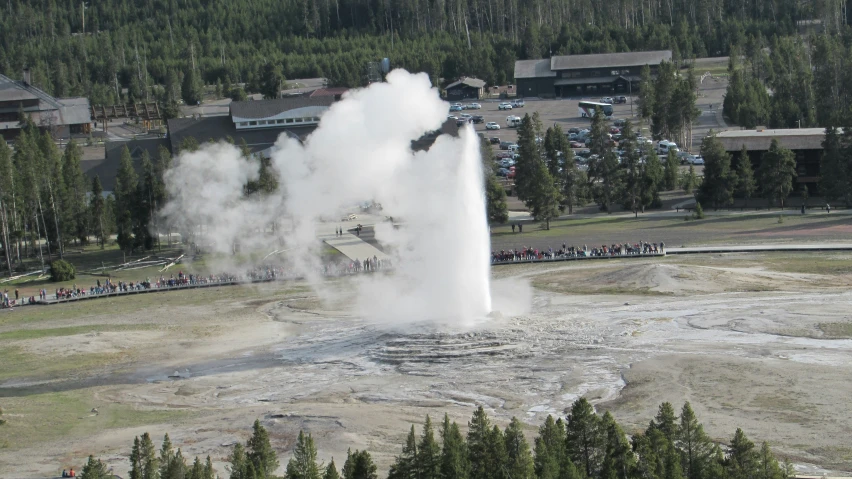 geyser in foreground of building while people are standing