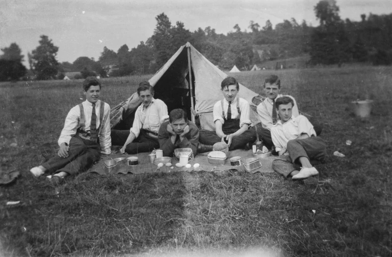 vintage pograph of people sitting outside of a tent