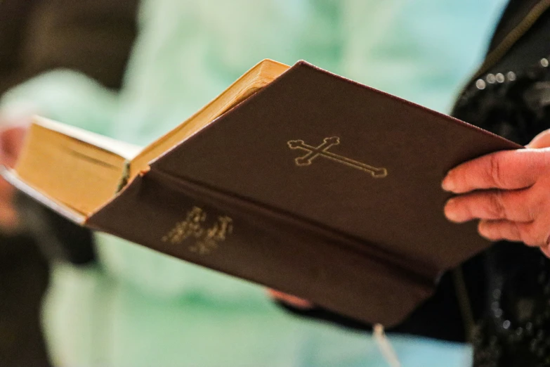 someone is holding a bible while standing in a room