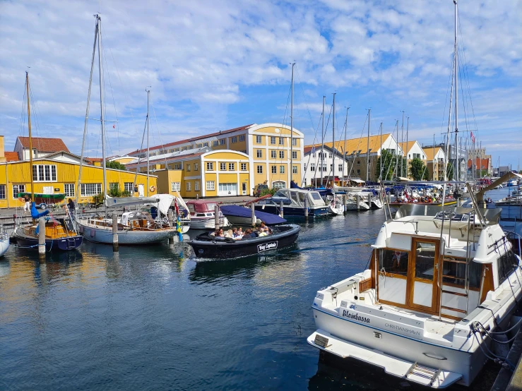 boats lined up on the docks by buildings in a harbor