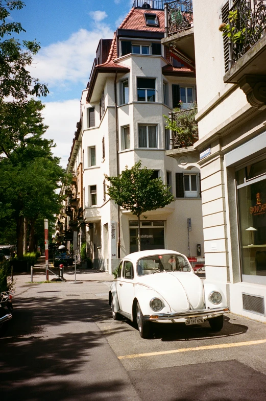 an old white car is parked in front of the building