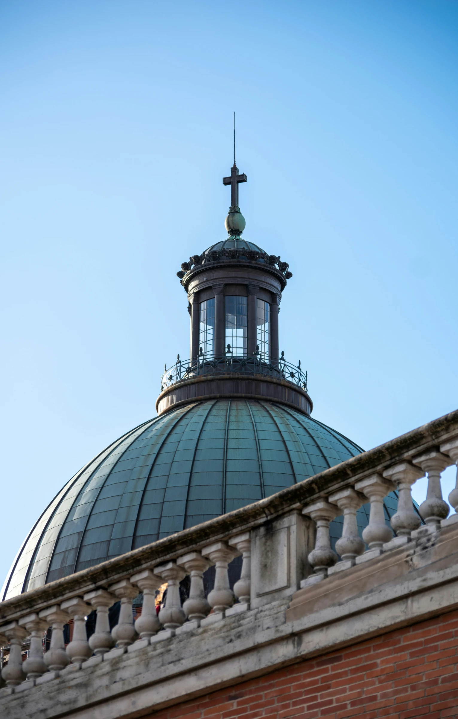 a building with a cross on top, with the blue sky