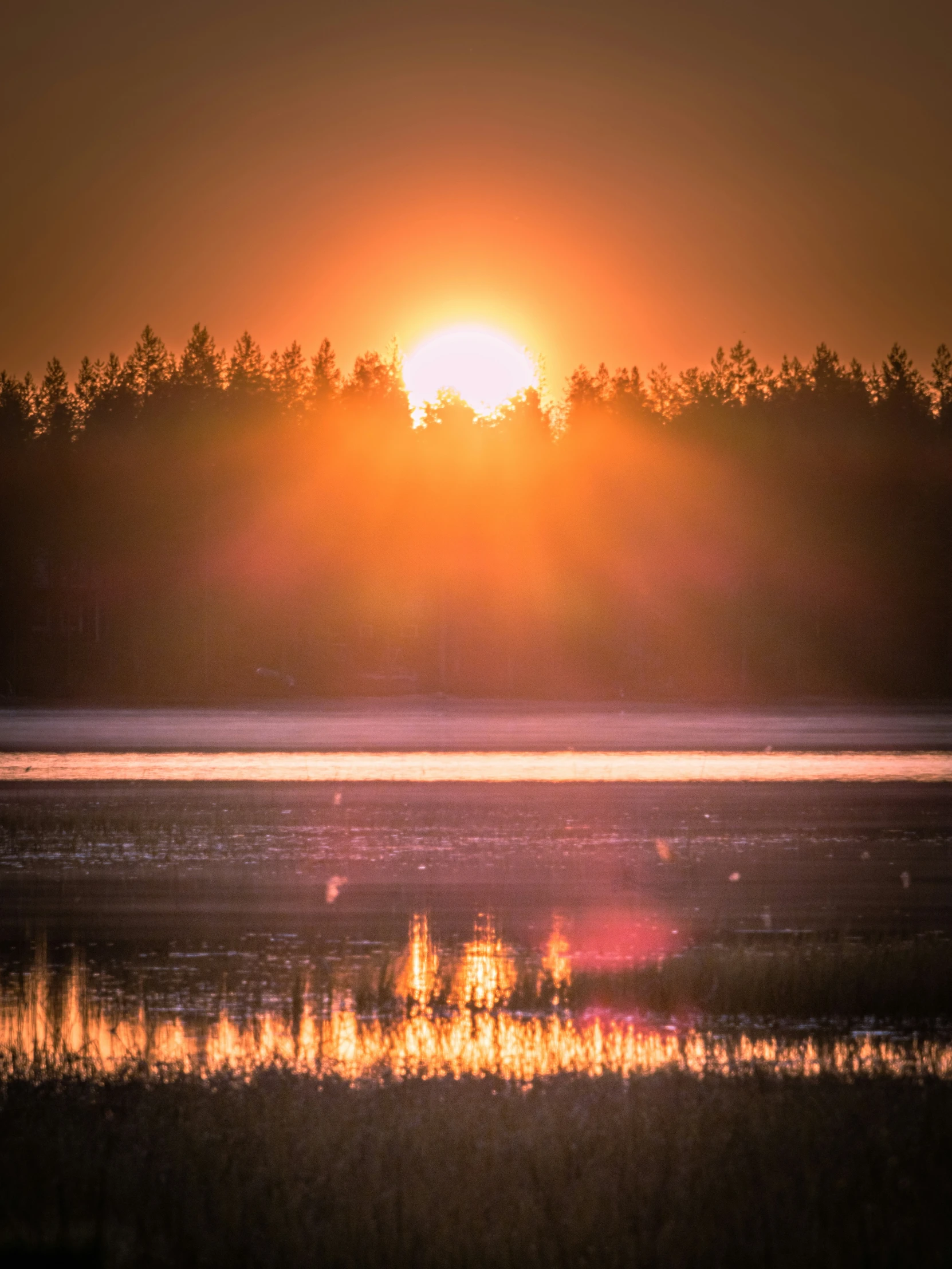 a po of the sun setting on a lake