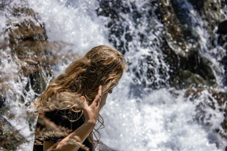 a woman standing in front of a waterfall