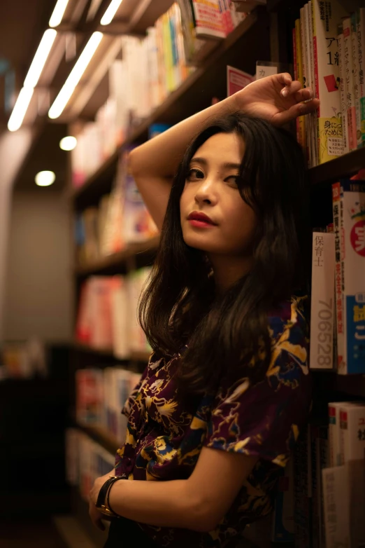 a woman leaning against a shelf of books