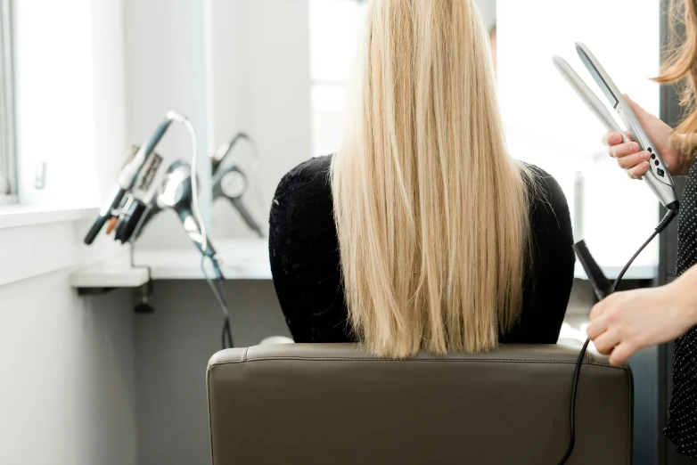 a woman getting her hair cut by another lady