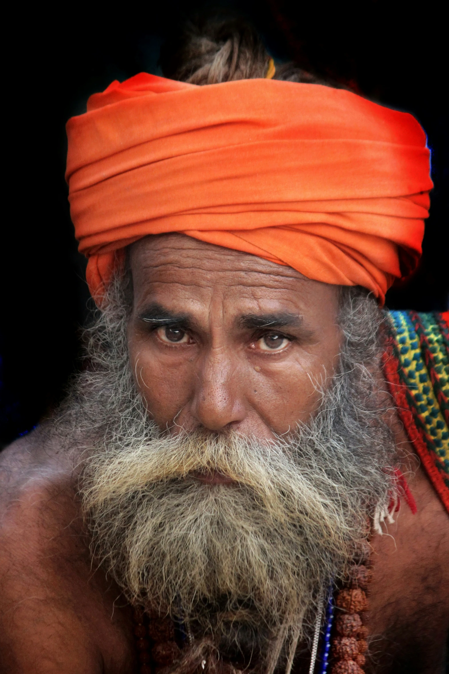 a man with orange head scarf and turban