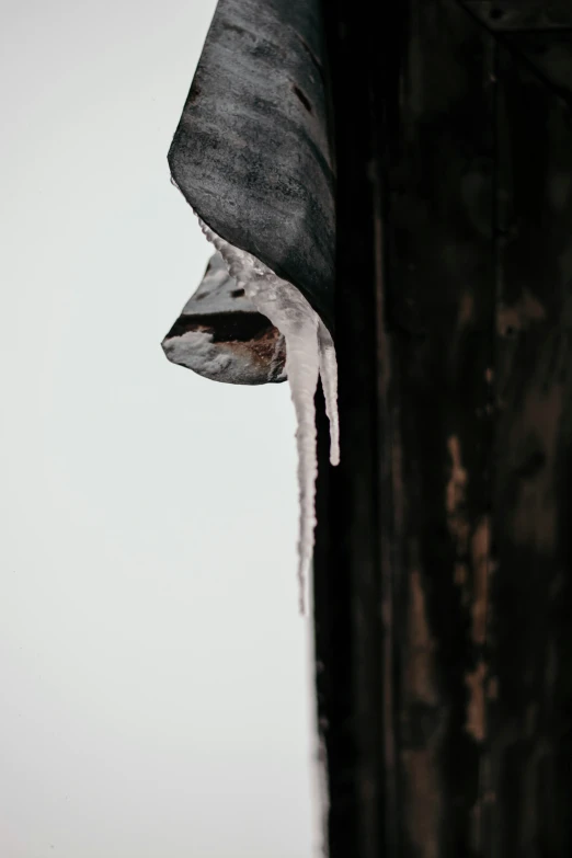 icicles hang off of a fence and in a bucket