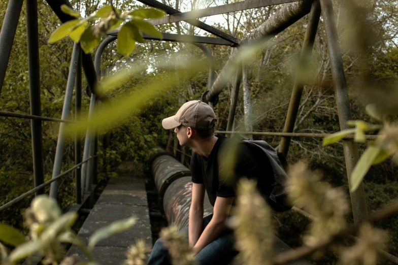 a woman sits on the edge of a bridge