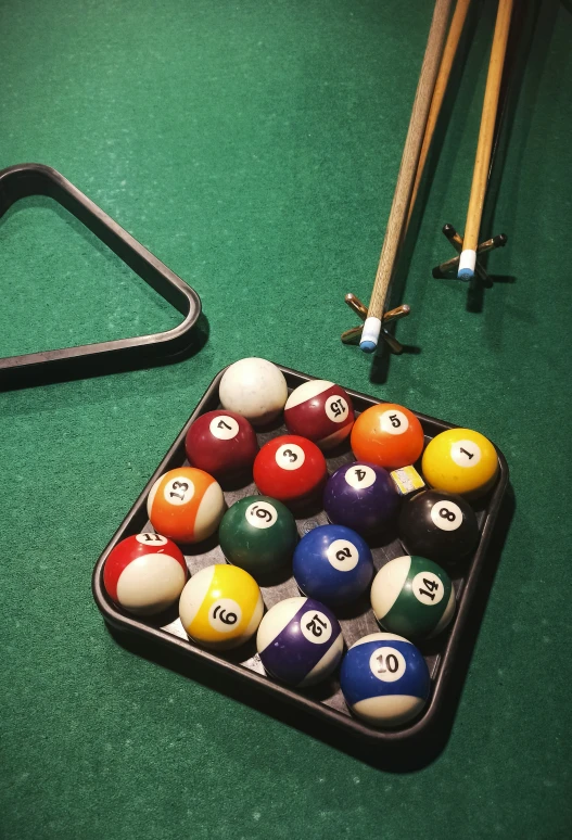 pool balls, cues and cues laying on a green surface