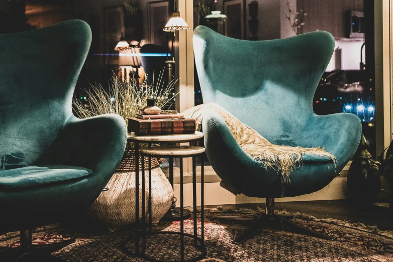 two green chairs and a table with an iron lamp