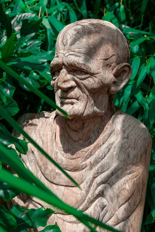 a statue of a person in front of some trees