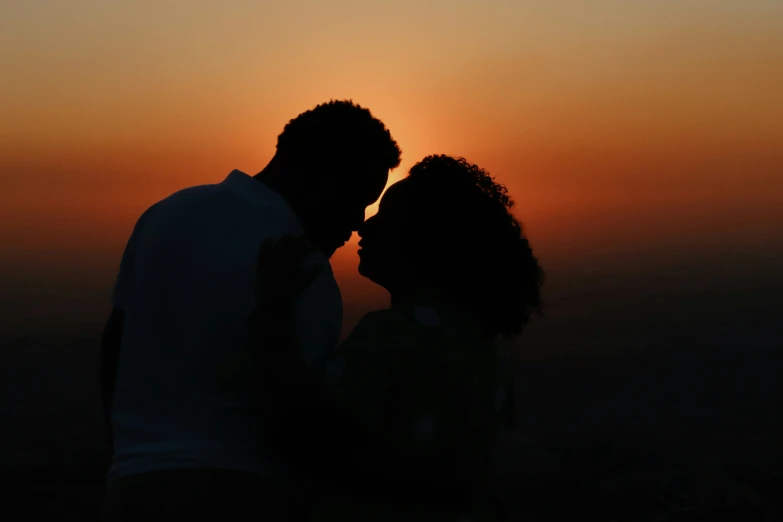 the silhouette of two people standing next to each other