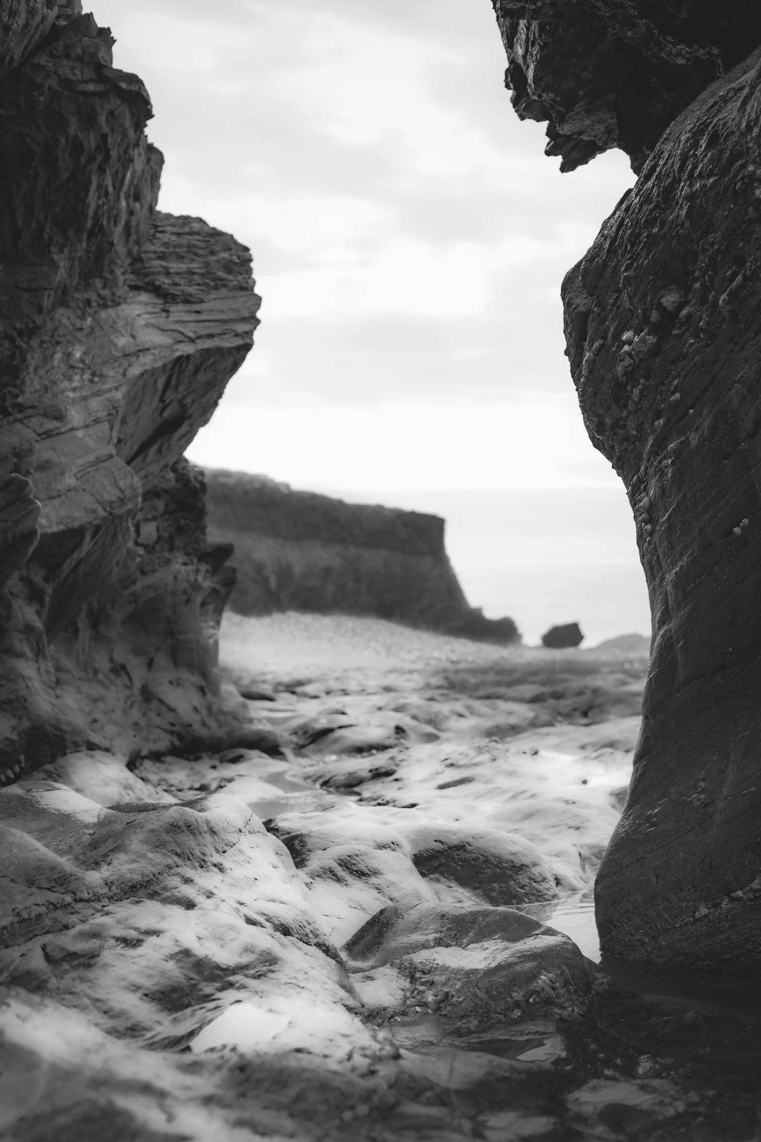 black and white pograph of a beach near rocks