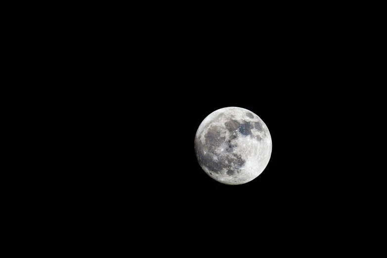 the dark side of the moon is visible with no clouds