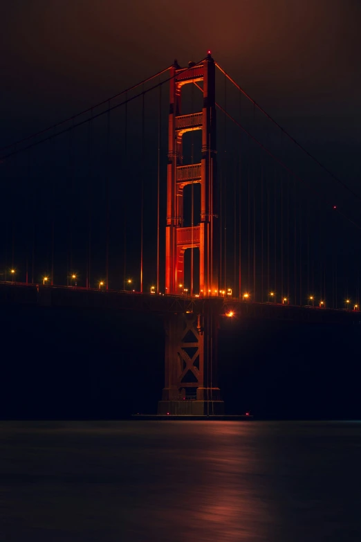 the golden gate bridge at night with lights reflecting off it