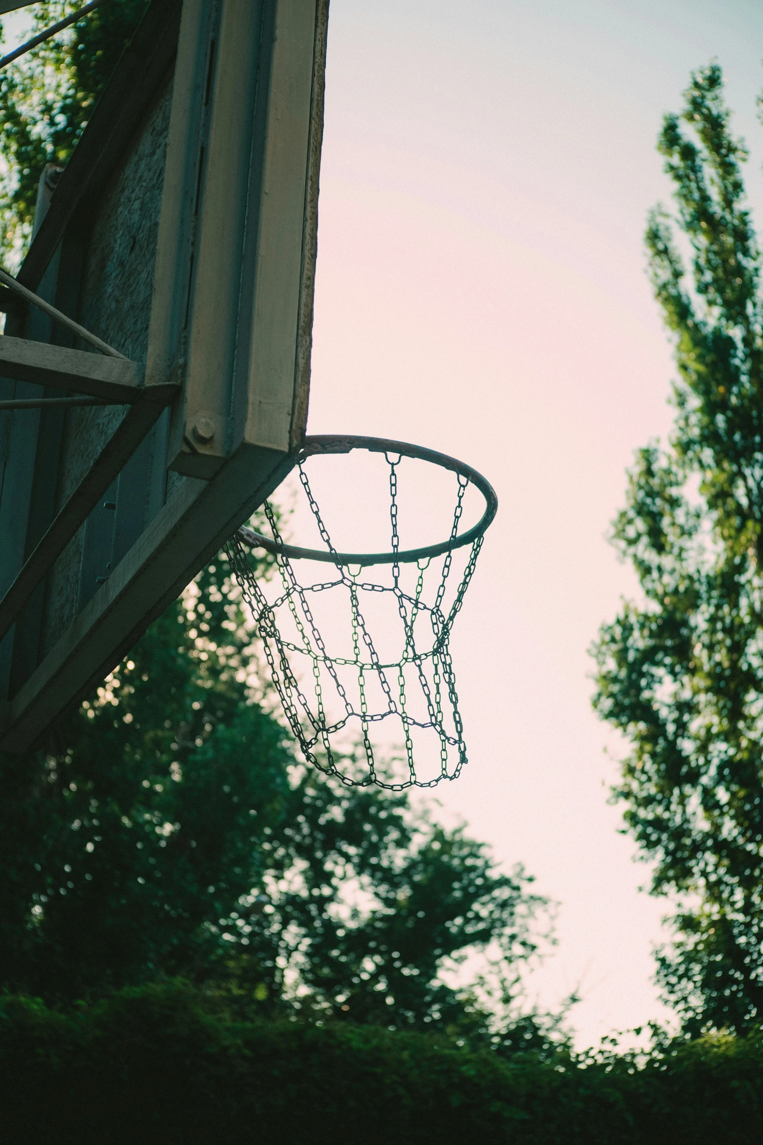 the back side of a basketball hoop with trees in the background