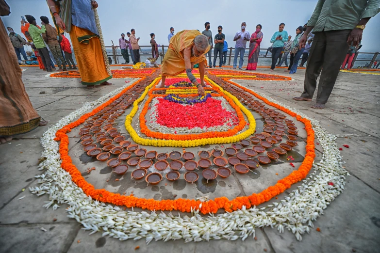 many people are looking at flowers laid out on the ground