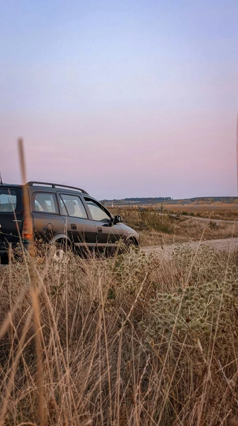 an suv that is parked on the side of the road in the grass